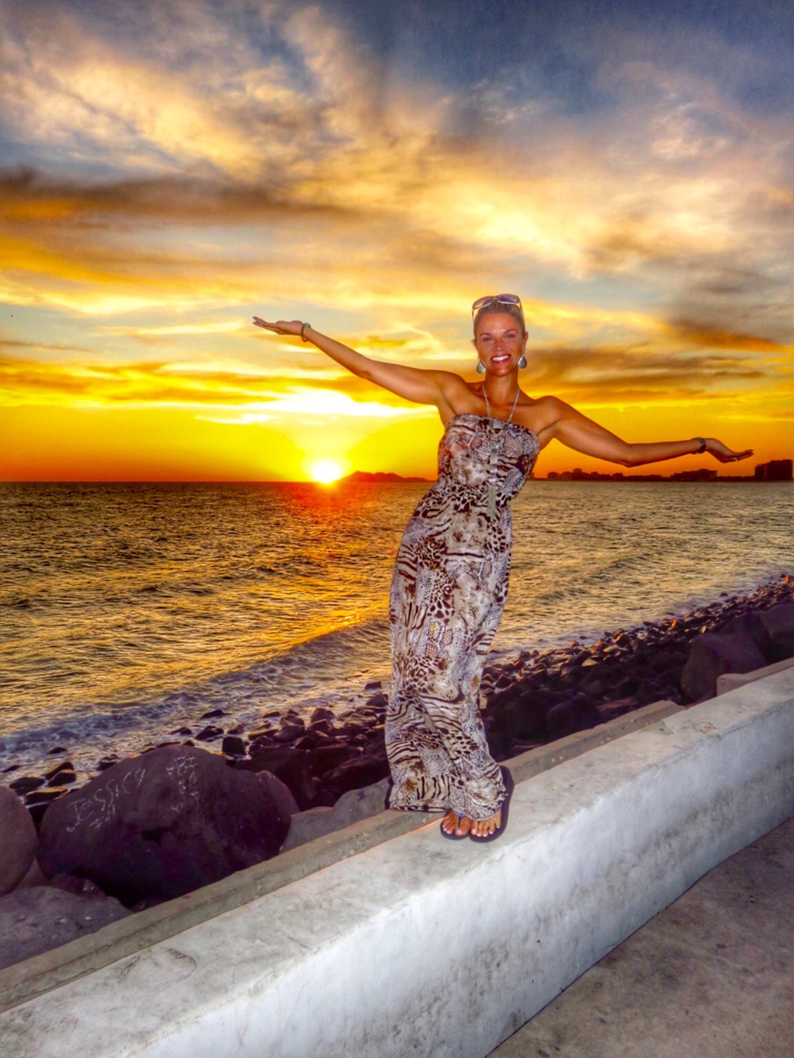 Camila at sunset beach in maxi dress arms open